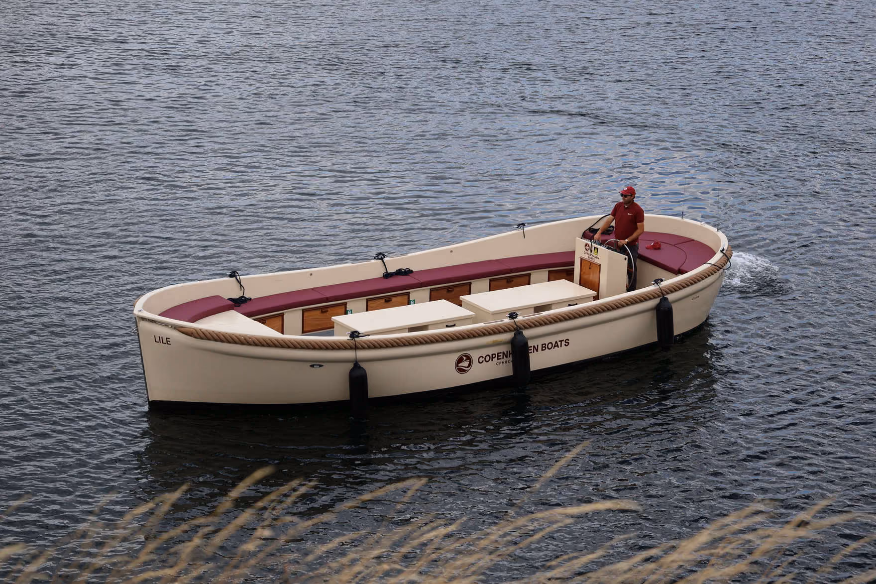 Skipper steering a Copenhagen Boats open boat across the harbour, seen from above